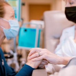 Nurse holding hands with patient in infusion room