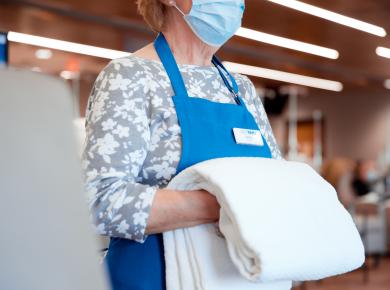 Volunteer holding blanket with apron on
